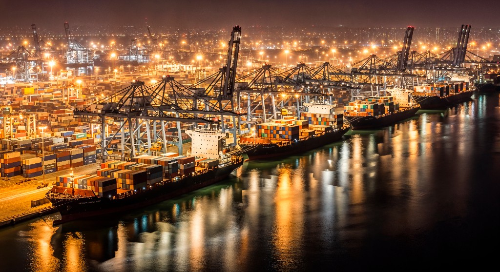 Port kontenerowy nocą z oświetlonymi statkami